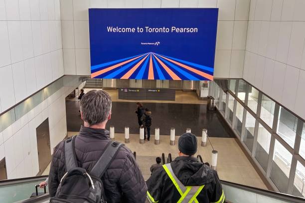 Toronto to New York: Every Way to Get There in 2026-2027 3 Departures board and travelers at Toronto Pearson Airport terminal